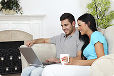 Couple interact with laptop computer.