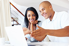 Persons interacting with laptop computer.