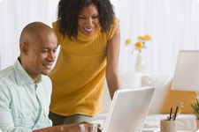 Couple interact with laptop computer.